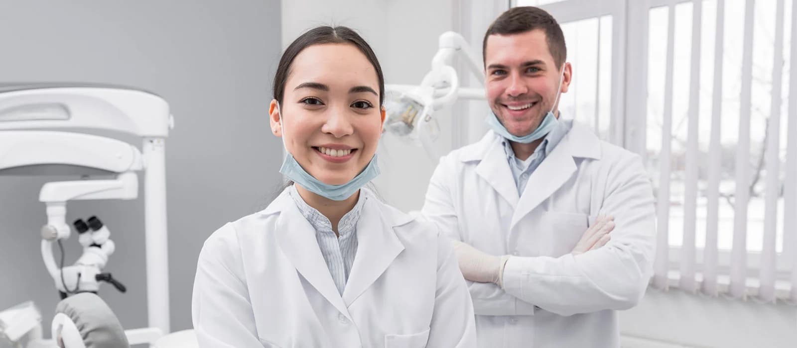 Smiling dentist and dental assistant standing in a dental clinic