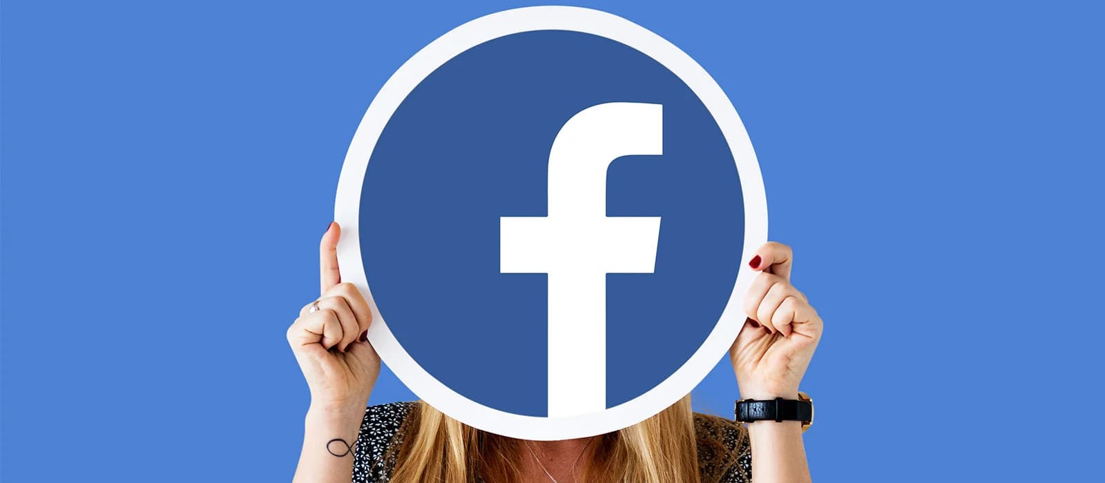 Person holding a large Facebook logo in front of their face